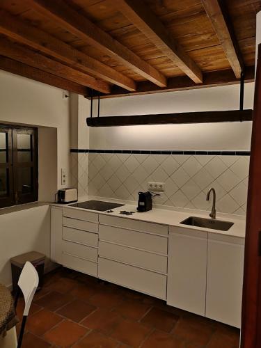 a kitchen with white cabinets and a sink at Casa Cuesta del Perro in Granada
