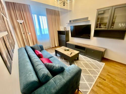 a living room with a blue couch and a table at Lazar Loft in Iaşi