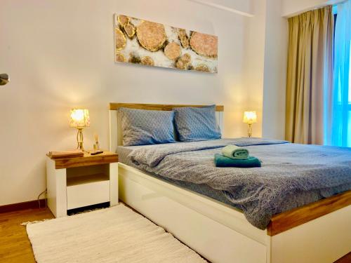 una camera da letto con un letto con lenzuola blu e due lampade di Lazar Loft a Iaşi