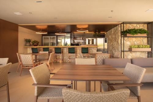 a restaurant with a wooden table and chairs at Amazon Aeroporto Hotel in Cuiabá