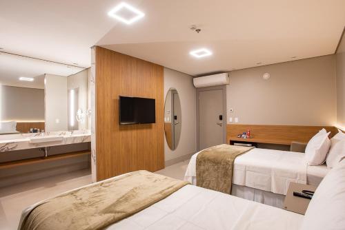 um quarto de hotel com duas camas e uma casa de banho em Amazon Aeroporto Hotel em Cuiabá
