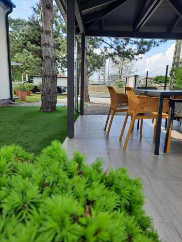 patio ze stołami i krzesłami oraz zielonymi roślinami w obiekcie Silver Lelle Apartman Balatonlelle w mieście Balatonlelle