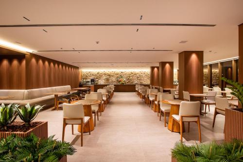um restaurante com mesas e cadeiras num quarto em Amazon Aeroporto Hotel em Cuiabá
