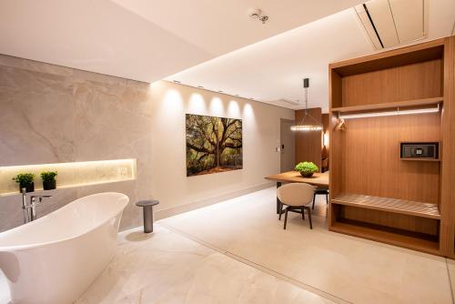 庫亞巴的住宿－Amazon Aeroporto Hotel，带浴缸和桌子的浴室