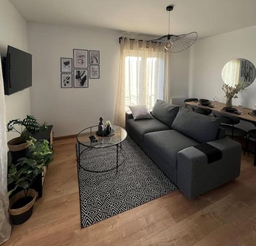 a living room with a couch and a table at Appartement proche Disneyland in Coulommiers