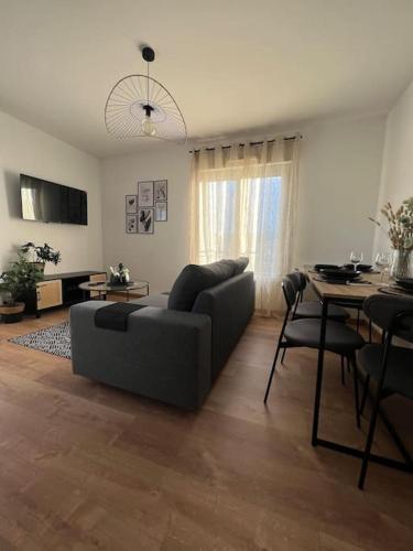 a living room with a couch and a table at Appartement proche Disneyland in Coulommiers