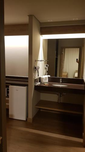 a bathroom with a sink and a mirror at Golden Gramado Resort Laghetto in Gramado