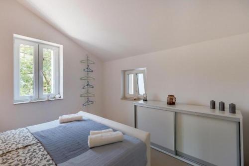 a white bedroom with a bed and a counter at Laguna in Nerezine