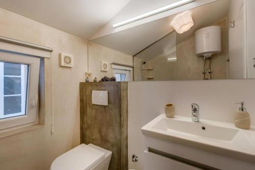 a bathroom with a sink and a toilet and a mirror at Laguna in Nerezine