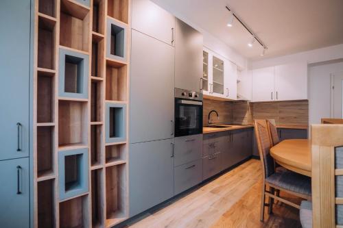 uma cozinha com armários brancos e uma mesa de madeira em Darki Apartments 4 - Very Central 100 Square Meters,Two Bedrooms,Free Parking em Ohrid