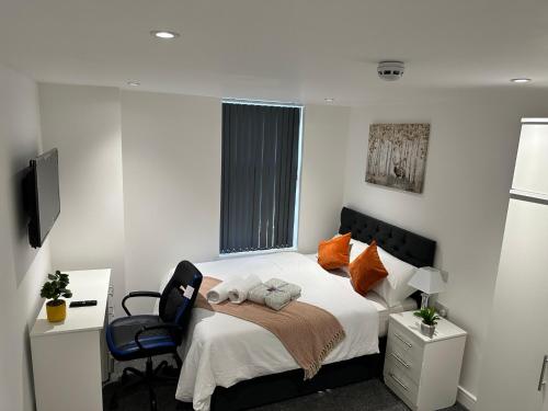 a small bedroom with a bed and a chair at Regent 28 in Coventry