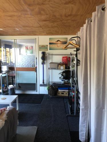 a living room with curtains and a room with a door at Sharyn’s B & B in Dunedin