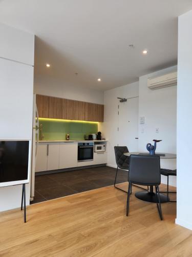 cocina y comedor con mesa y sillas en Stay Max Apartment for Perfect Short Stay, en Auckland