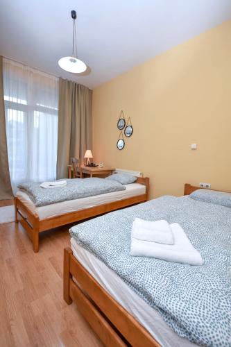 a room with two beds and a table with a window at Apartment Studenac in Banja Luka