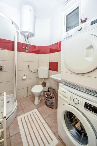 a bathroom with a washing machine and a toilet at Apartment Studenac in Banja Luka