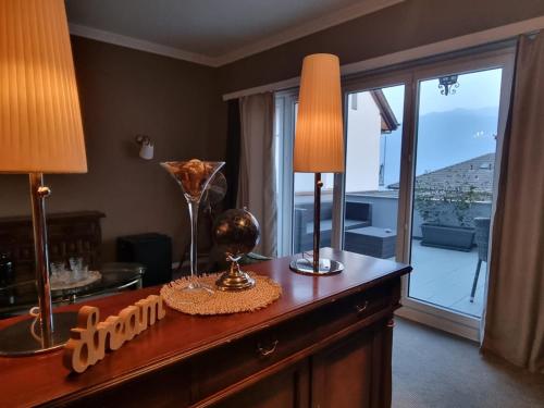 ein Wohnzimmer mit einem Tisch mit zwei Lampen und einem Fenster in der Unterkunft Boutique Centrale in Brione sopra Minusio