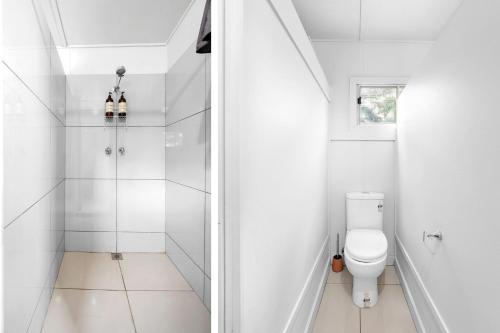 a white bathroom with a shower and a toilet at Fentons Run High Range in Joadja Creek