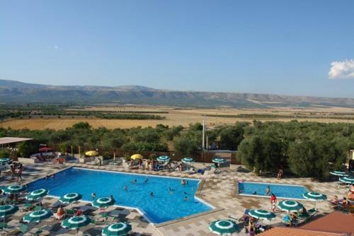 a large swimming pool with umbrellas and umbrellas at Tenuta Chianchito in San Giovanni Rotondo