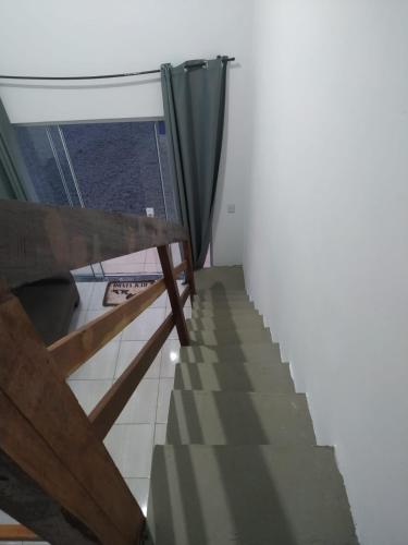 a room with a staircase with a curtain and a window at Loft/APTO em Praia da Pinheira in Pinheira
