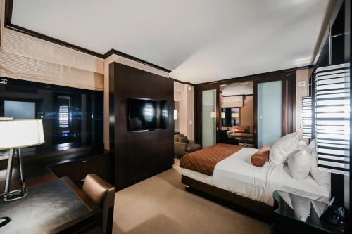 a bedroom with a bed and a desk in a room at StripViewSuites at Vdara in Las Vegas