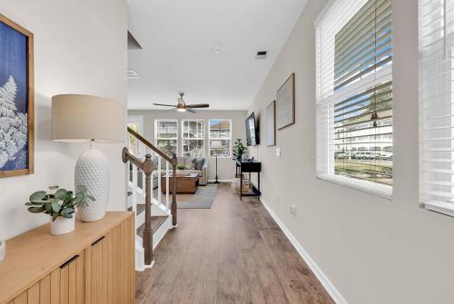a hallway with white walls and a staircase with a window at Centrally Located Myrtle Beach House Near Sports Center, Broadway at the Beach, Shopping, Beach, and Golf in Myrtle Beach