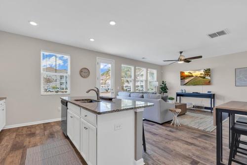 a kitchen and living room with a sink and a table at Centrally Located Myrtle Beach House Near Sports Center, Broadway at the Beach, Shopping, Beach, and Golf in Myrtle Beach