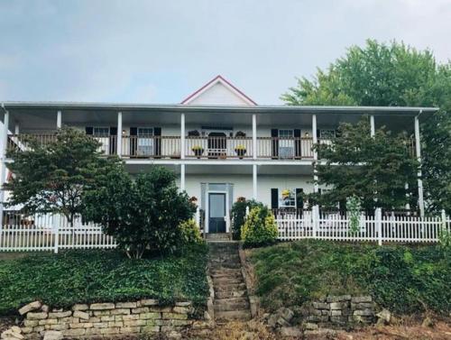 a white house with a white fence at Rocky Hill Inn in Smiths Grove