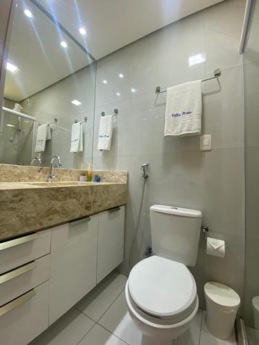 a white bathroom with a toilet and a sink at Suíte ACONCHEGO no Villa do porto a 300m do Beach Park e a 5 minutos a pé da praia in Aquiraz