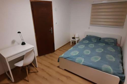 a bedroom with a bed and a desk and a computer at Old Cherry Apartment in Vračar (historical)