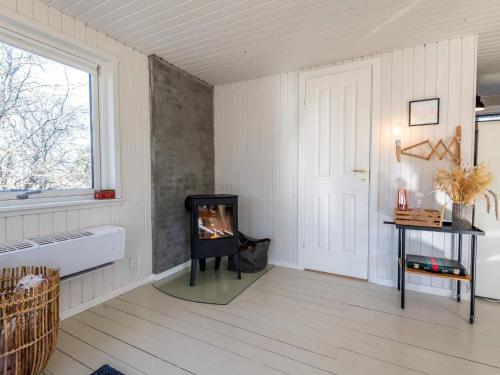 een woonkamer met een open haard en een raam bij Holiday home Fanø CCVII in Fanø