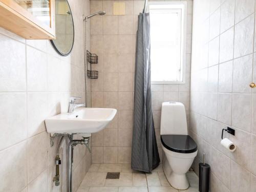 een badkamer met een wastafel, een toilet en een raam bij Holiday home Fanø CCVII in Fanø