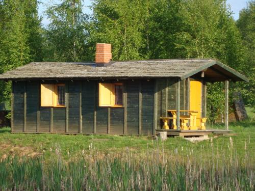 a small green house with a table and chairs in it at Līgatnes Zemturi in Augšlīgatne