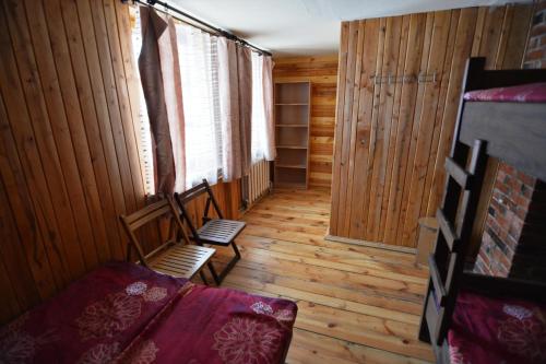 a room with two chairs and a window in a cabin at Līgatnes Zemturi in Augšlīgatne