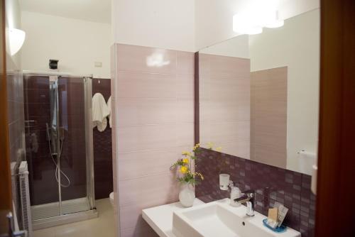 a bathroom with a sink and a shower and a mirror at Garibaldi R&B in Messina