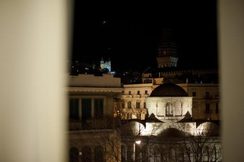 a lit up building with a clock tower at night at Garibaldi R&B in Messina