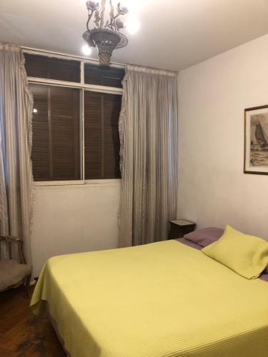 Un dormitorio con una cama amarilla y una ventana en Departamento centrico en mendoza en Mendoza