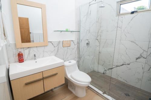 uma casa de banho com um chuveiro, um WC e um lavatório. em Equinoccio Hotel em Santa Ana