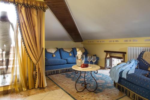 un soggiorno con divani blu e un tavolo di UNICA Assisi agri-charming house ad Assisi