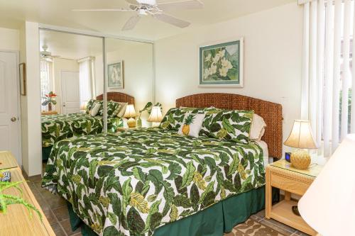 Schlafzimmer mit einem Bett und einem Spiegel in der Unterkunft Hale Kamaole 117 in Wailea