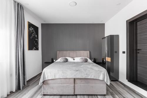 a bedroom with a large bed with white walls at Luxury room Ekstaza in Solin