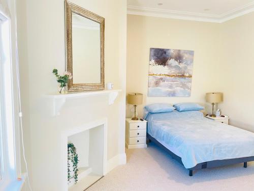 a white bedroom with a bed and a mirror at Classic Meets Modern in Central Wagga in Wagga Wagga