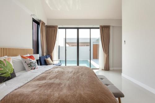 a bedroom with a bed and a view of a pool at Private Pool Villa Newly-built Vimalai house in Pattaya in Nong Prue