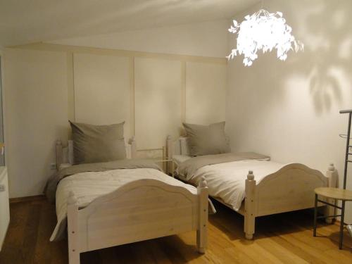 two beds in a bedroom with a chandelier at Kleine Residenz am Zehnthof in Senheim