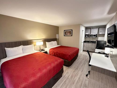 ピンチャー・クリークにあるフットヒルズ モーテルのベッド2台とキッチンが備わるホテルルームです。