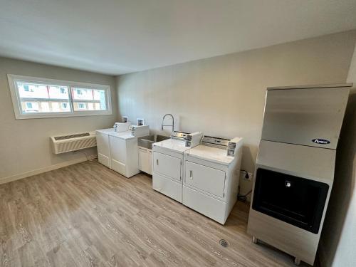 a laundry room with white appliances and a window at Econo Lodge Inn & Suites in Pincher Creek