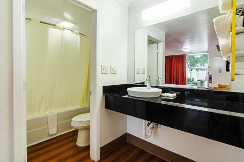 a bathroom with a sink and a toilet and a mirror at Motel 6-Bay Minette, AL in Bay Minette