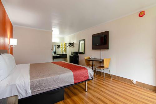 um quarto de hotel com uma cama e uma televisão de ecrã plano em Motel 6-Bay Minette, AL em Bay Minette
