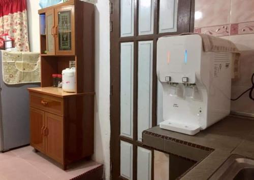 a room with a machine next to a wooden table at MK AL-ATTAS HOMESTAY - KUALA BESUT in Kampong Nail