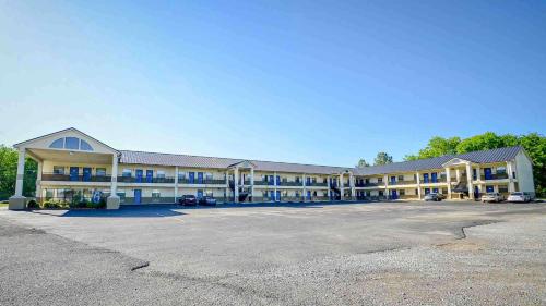 um grande edifício com um parque de estacionamento em frente em Motel 6-Atoka, OK em Atoka