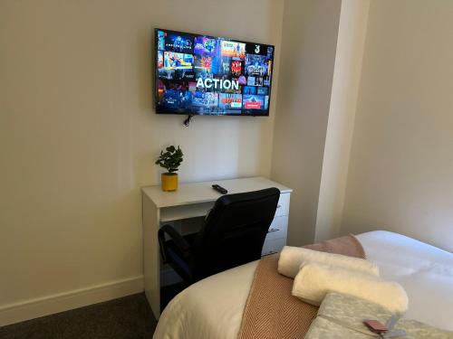 a bedroom with a desk and a television on the wall at Regent 28 in Coventry